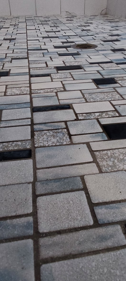 Mosaic shower floor before restoration with darkened grout lines